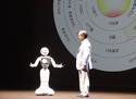 SoftBank CEO Masayoshi Son talks to the mobile carrier's communications robot Pepper while its emotion map is displayed behind them at an event in Maihama, Japan, June 18, 2015. 